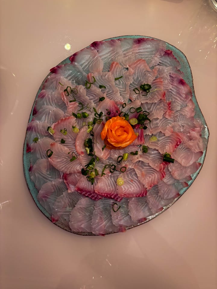 Sashimi de peixe branco em espiral com rosa de salmão ao centro