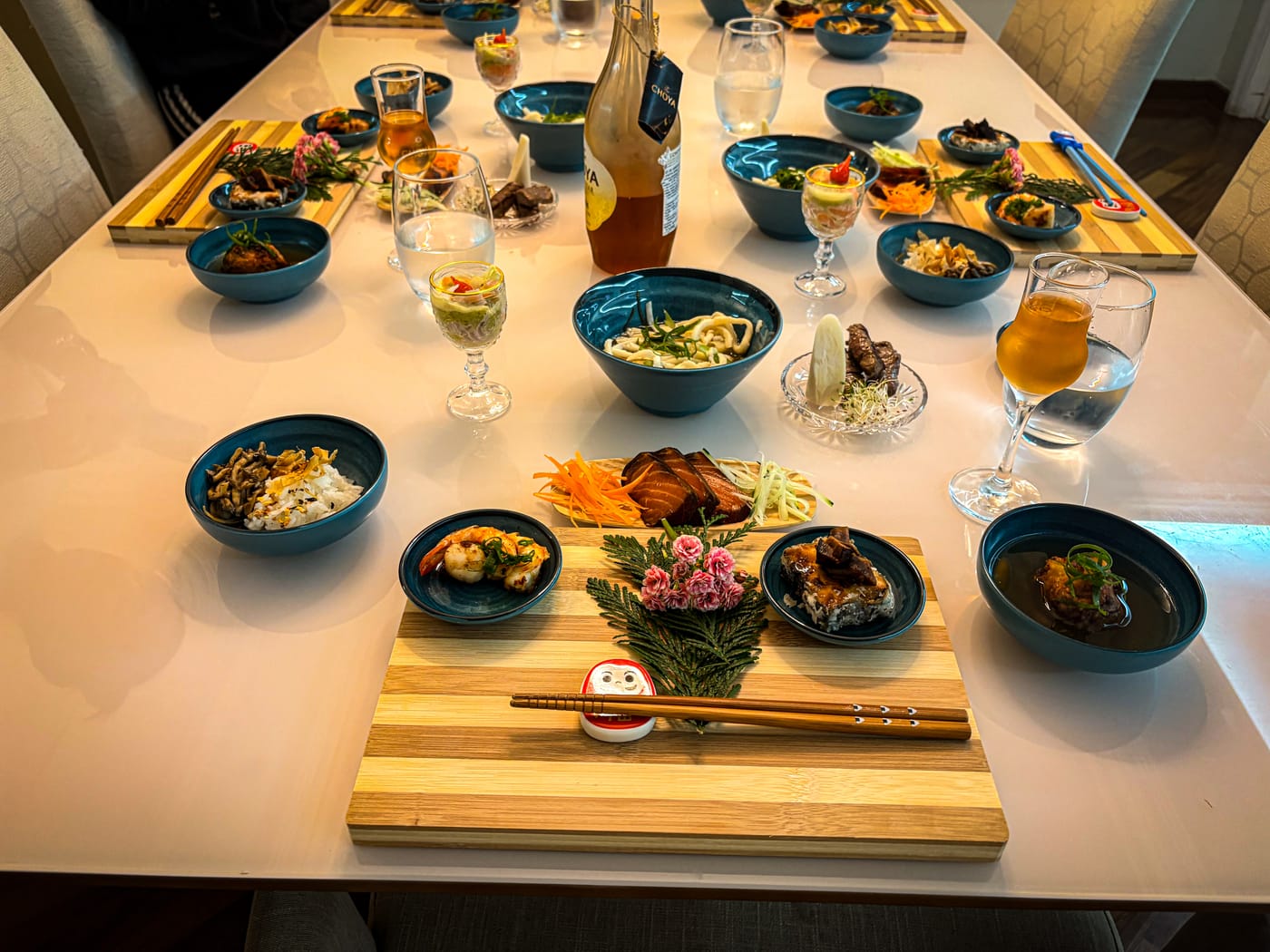Mesa de jantar completa montada em ambiente real, com pratos variados e taças